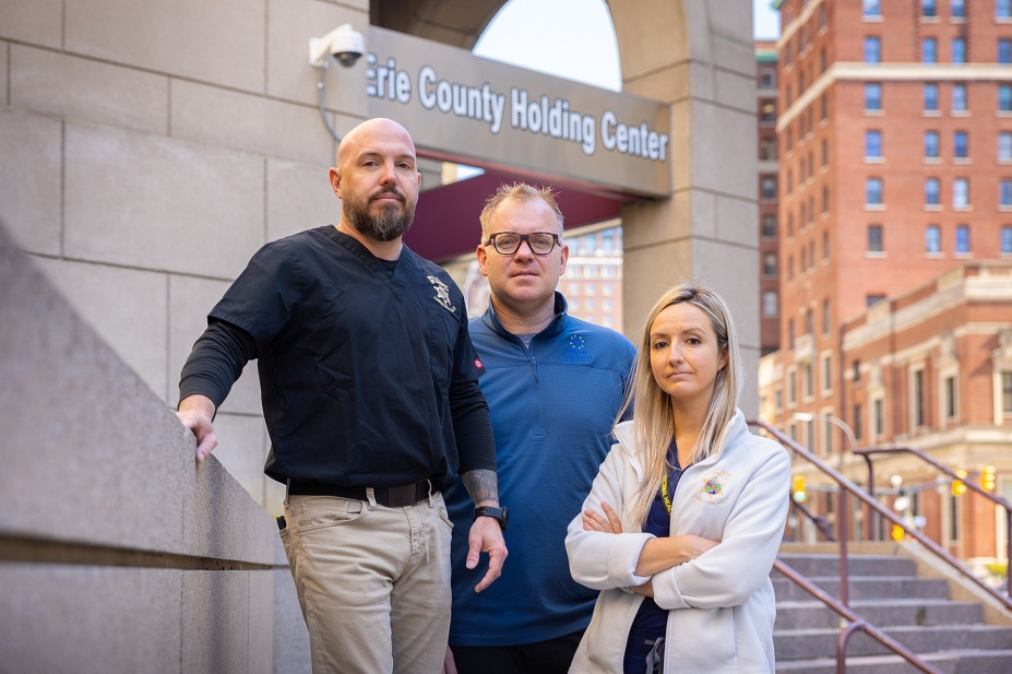 Kevin McGee (left), with UBMD, Josh Lynch (center), with JSMBS, and Amanda Martinez, a nurse practitioner with the Erie County Sheriff&rsquo;s Office, pictured in front of the Erie County Holding Center. 