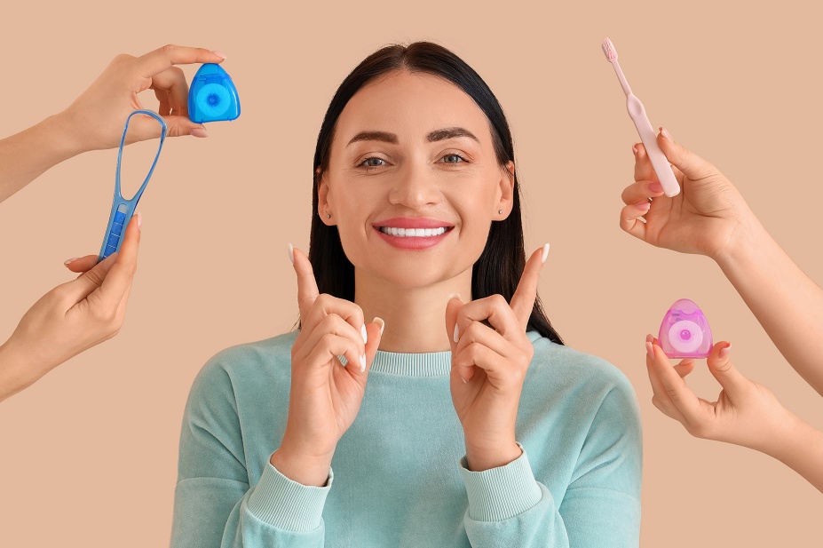 A smiling woman surrounded by dental hygene implimnets. 